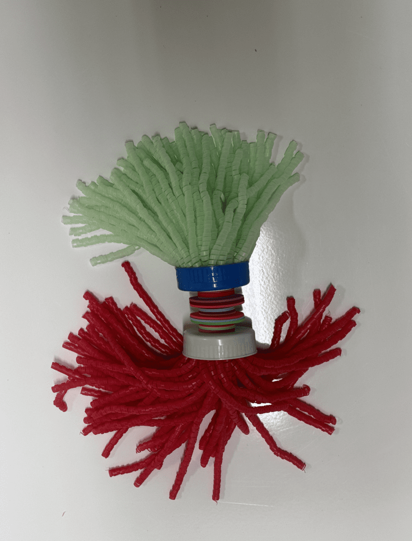 A red and green Jellyfish on a white surface.